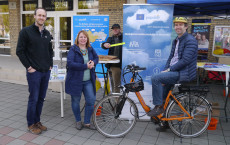 Manažéri kvality ovzdušia (jeden z nich na bicykli) a projektový stánok populair